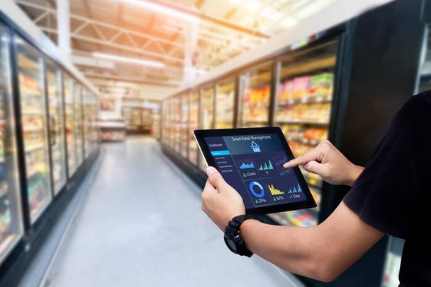 Smart Retail Management System. Arbeiter Hände halten Tablet auf verschwommenem Supermarkt als Hintergrund - Foto, Bild