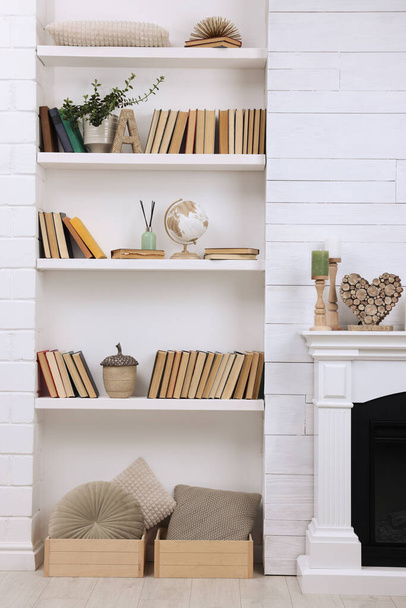 Collection of books and decor elements on shelves indoors. Interior design - Photo, Image