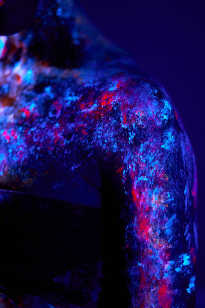 Close-up photo of black female skin with fluorescent paintings, body art - Foto, Bild