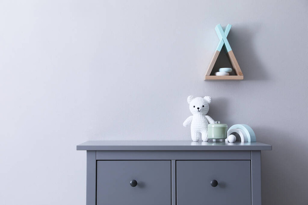 Child's toys on chest of drawers near light grey wall indoors - Zdjęcie, obraz