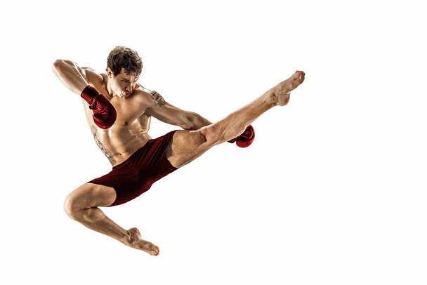 Full size of athlete boxer who perform muay thai martial arts on white background. Red sportswear  - Φωτογραφία, εικόνα