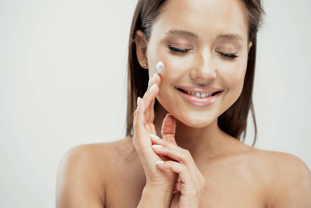 beautiful face, woman applies anti-aging cream cosmetics profess - Foto, imagen