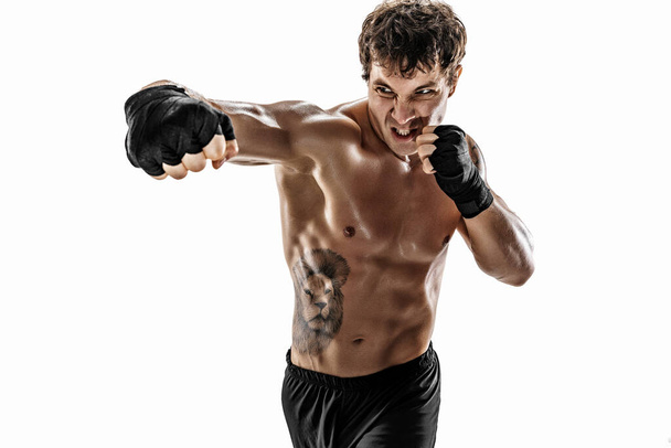 Portrait of aggressive boxer who training and practicing swing on white background. Sport concept  - Photo, image