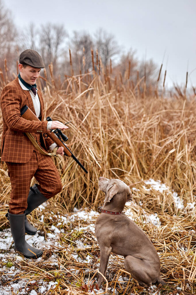 Hunting period, autumn season open. male hunter give commands, training the dog - Photo, image