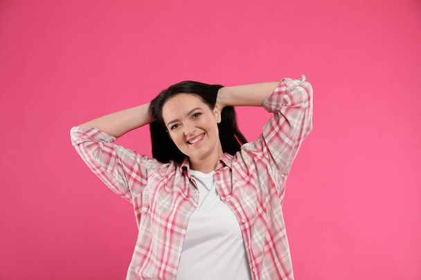 Beautiful overweight woman with charming smile on pink background - Foto, afbeelding