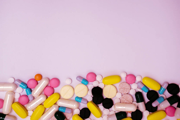 Pile a gyógyszerek kapszulák és tabletták a különböző színű fehér alapon - Fotó, kép
