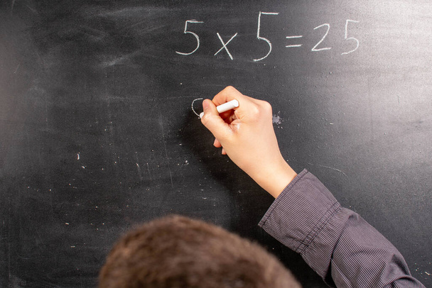Boy lecturing mathematics at a blackboard - Фото, зображення