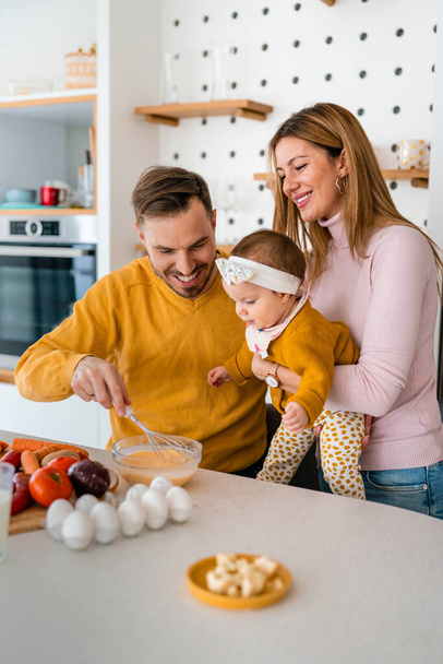 Happy family preparing healthy food together in kitchen at home - Fotoğraf, Görsel
