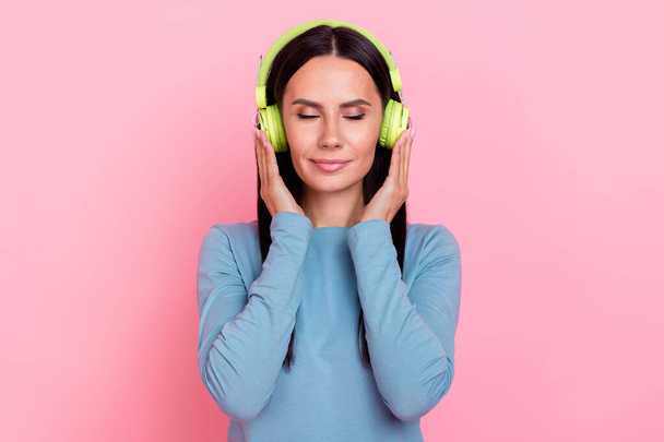Photo of charming pretty woman wear blue shirt enjoying music arms headphones isolated pink color background - Foto, immagini