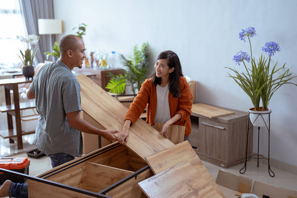Couple moving in together assembling furniture table - 写真・画像