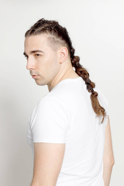 Stylish male model with braids posing in studio on isolated background. Style, hairstyle, fashion concept. - Fotoğraf, Görsel