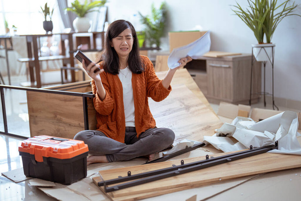 frustrated asian woman while assembling new furniture - Photo, Image