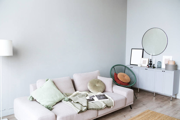 Tyylikäs huoneen sisustus tehty harmaita värejä ja skandinaaviseen tyyliin. Huoneessa on sohva, konsoli ja peili. - Valokuva, kuva