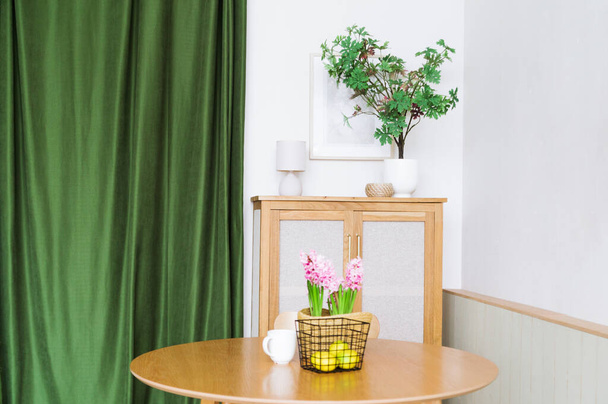 L'intérieur de la cuisine est fait de matériaux naturels. Il y a des plantes, une table et un rideau vert dans la cuisine. - Photo, image