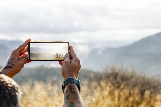 Mani ritagliate Fotografare cielo nuvoloso attraverso Smart Phone durante l'estate - Foto, immagini