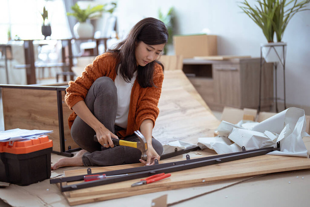 young asian female assembling furniture on her own - Fotó, kép