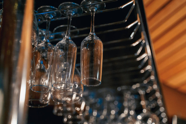 transparent glasses for drinks hang on the bar, nightlife, order - Foto, Imagen