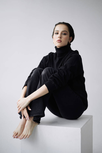 Good series of photos of young pretty woman. Studio. European type, big lips, awesome eyes, slim body. White background. Black clothes. Emotional. Minimalism. Stylish. Fashionable and modern lifestyle - 写真・画像