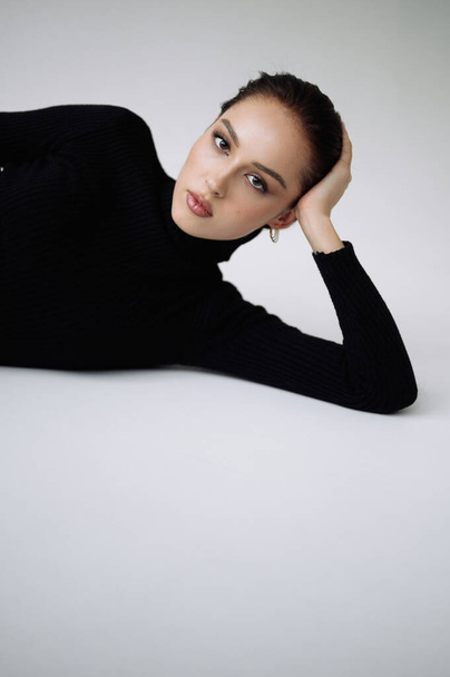 Good series of photos of young pretty woman. Studio. European type, big lips, awesome eyes, slim body. White background. Black clothes. Emotional. Minimalism. Stylish. Fashionable and modern lifestyle - 写真・画像
