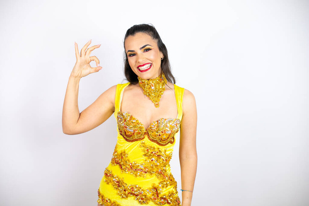 Young beautiful woman wearing carnival costume over isolated white background doing ok sign with fingers and smiling, excellent symbol - Foto, imagen