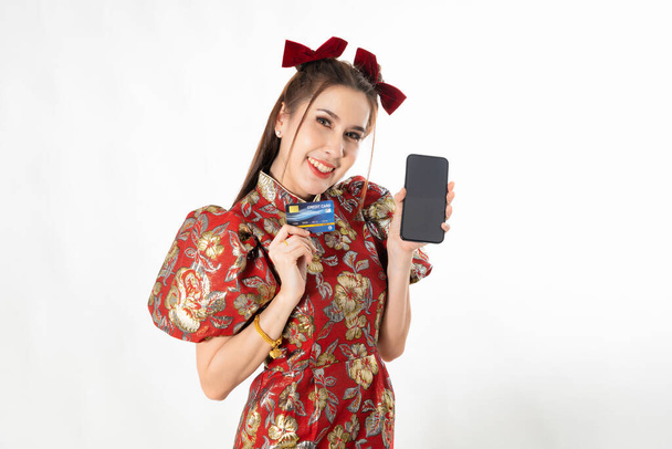 Happy chinese new year. excited young Woman showing blank smart phone screen, with credit card, mobile smart phone shopping online technology concept on white isolated background - Valokuva, kuva