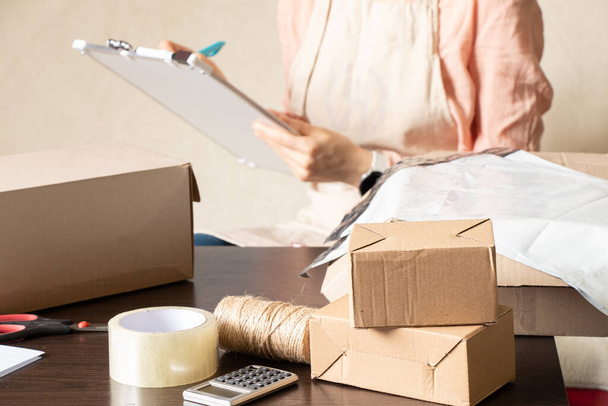 Frauen-Online-Shop, Kleinunternehmer, Unternehmer, Packtasche, Briefkasten Vorbereitung Paket auf dem Tisch für den Versand. Dropshipping Delivery Konzept im E-Commerce. Produktverpackungen - Foto, Bild