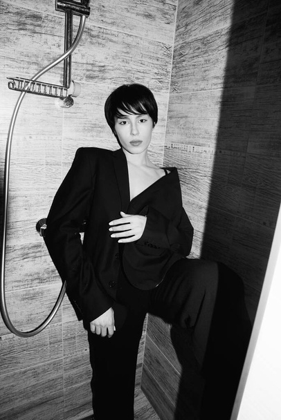 Asian girl in the shower. Black suit. Short wet hair. Beautiful eyes and lips. Sexy, young, crazy and cool. Pure white skin. Nice shape. Good quality. Flashlight. Modern and stylish. Black and white - Фото, зображення