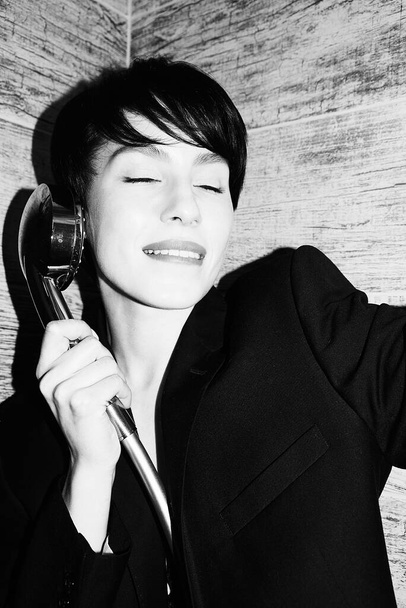 Asian girl in the shower. Black suit. Short wet hair. Beautiful eyes and lips. Sexy, young, crazy and cool. Pure white skin. Nice shape. Good quality. Flashlight. Modern and stylish. Black and white - Photo, Image