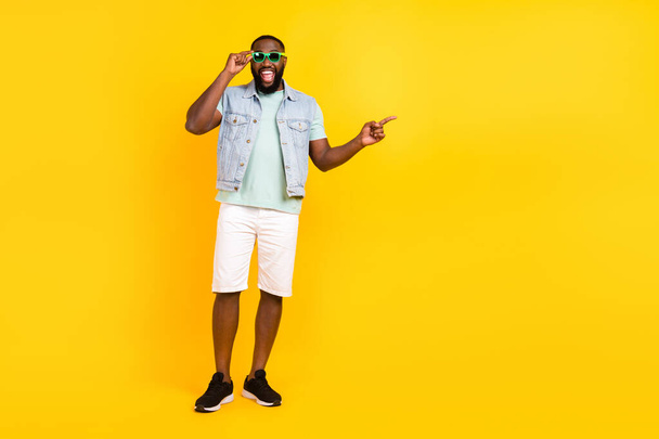 Full length body size view of handsome trendy cheery guy showing copy space isolated over bright yellow color background - Fotoğraf, Görsel