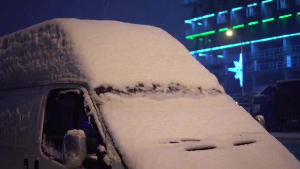 De winter. Geparkeerde auto 's waren bedekt met sneeuw. Er waait een harde wind. - Video