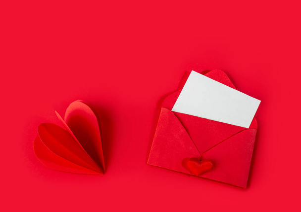 Czerwona koperta z pustą wizytówką. Świąteczne pozdrowienia w Walentynki, Dzień matki, Chiński Nowy Rok. - Zdjęcie, obraz