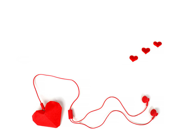 cuffie, cuori di carta rossa su sfondo bianco isolato. note musicali sotto forma di cuori. ascoltare musica d'amore. - Foto, immagini
