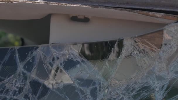 Close-up schot van een auto voorruit gebroken door een plank. - Video