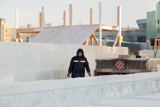 Buz kasabasının toplanma yerinde elinde kova olan bir işçi. - Fotoğraf, Görsel