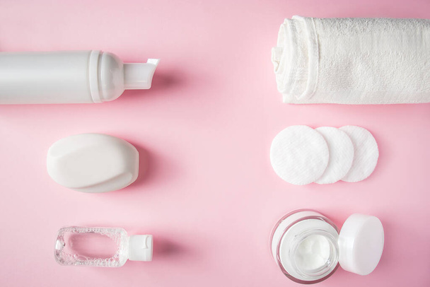 Cosmetic products on pink background. White bottles of cream and lotion. Spa accessories, body care. Wellness concept. - Photo, Image