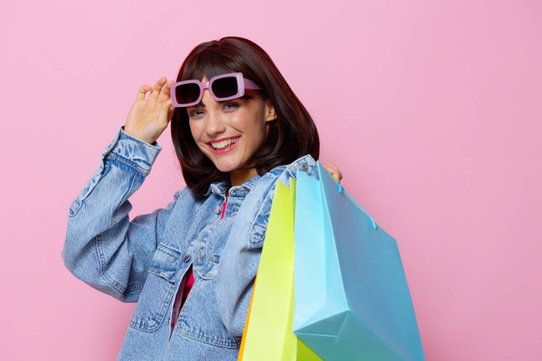 Frau in Jeansjacken mit bunten Einkaufstaschen Lifestyle-Mode - Foto, Bild
