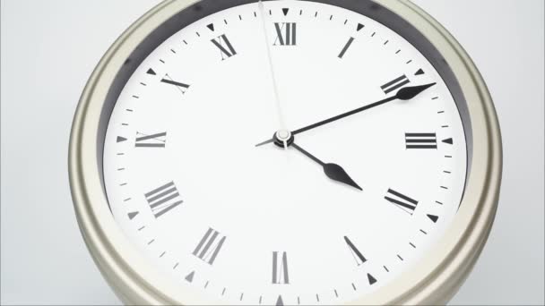 Czas upływa srebrny zegar ścienny mówi czas na godzinie 5. Pokazuje upływ czasu na rzymskich cyfrach. Na białym tle. - Materiał filmowy, wideo