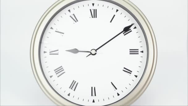 Zeitraffer Silberne Wanduhr zeigt die Zeit von 3 Minuten bis 10 Uhr an. Zeigt den Lauf der Zeit auf römischen Ziffern. Auf weißem Hintergrund. - Filmmaterial, Video