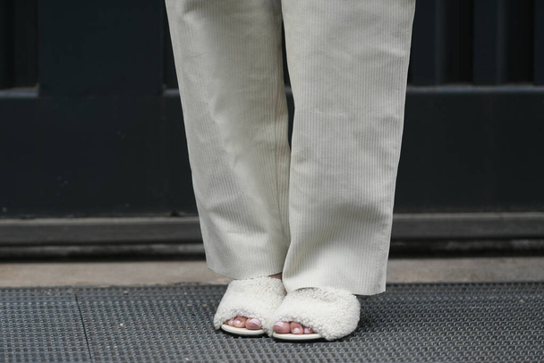 Street style outfit - woman wearing puffy shoes and cream white pants - Foto, imagen