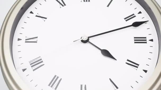 Időeltolódás ezüst falióra megmondja az időt 3 perc 10 óra. Megmutatja az idő múlását a római számokon. Fehér alapon. - Felvétel, videó