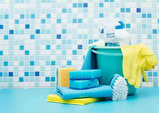 Reiniger und Reinigungsmittel im Eimer, Zubehör zur Reinigung verschiedener Oberflächen und Räume blauer Hintergrund - Foto, Bild