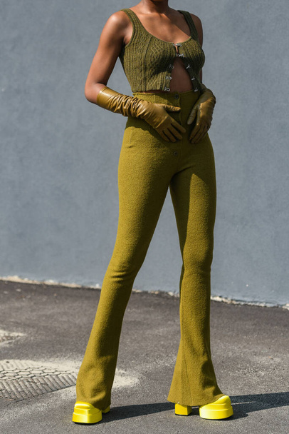 Straat stijl outfit - vrouw draagt een mosterd top, mosterd broek en neon gele platform schoenen - Foto, afbeelding