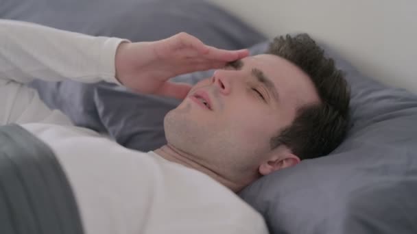 Άντρας που έχει πονοκέφαλο ενώ κοιμάται στο κρεβάτι, κοντινό πλάνο - Πλάνα, βίντεο