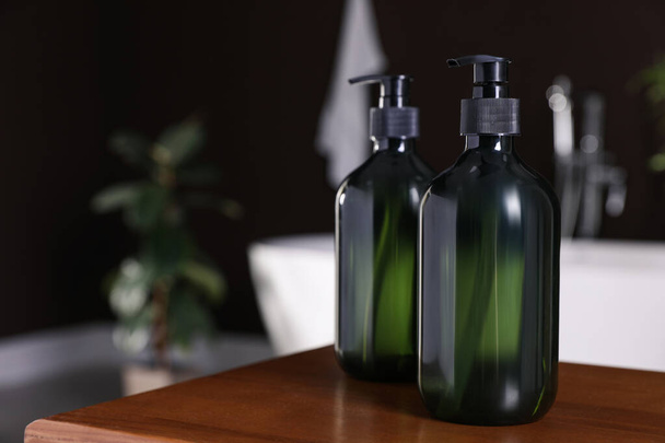Dispensers of liquid soap on wooden table in bathroom, space for text - Fotografie, Obrázek