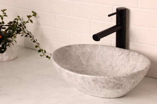 Stone vessel sink with faucet on white marble countertop - Valokuva, kuva