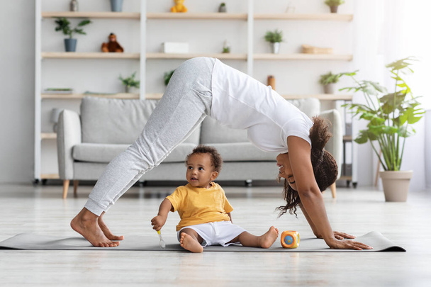 Motherhood And Fitness. Happy Black Woman Exercising With Little Son At Home - Foto, afbeelding