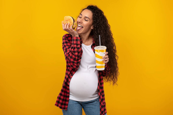 Funny Young Pregnant Lady Holding Burger And Drink - Foto, afbeelding
