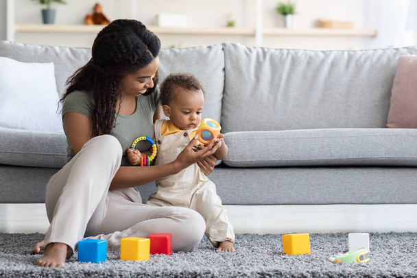 Activités avec les bébés. Maman noire jouant des jouets avec le fils infantile à la maison - Photo, image