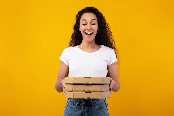 Ευτυχισμένη λατινική κυρία κρατώντας κουτιά πίτσα στο στούντιο - Φωτογραφία, εικόνα