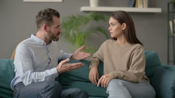 Σοβαρός άντρας που μιλάει με γυναίκα ενώ κάθεται στον καναπέ  - Πλάνα, βίντεο